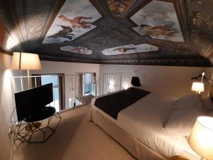 莱万托帕拉佐瓦诺尼酒店的一间卧室配有一张床,天花板上装饰有绘画作品