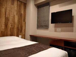 名古屋HOTEL ERENOA - Vacation STAY 69058v的一间卧室配有一张床和一台平面电视