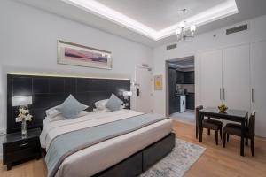 迪拜Rose Garden Hotel Apartments - Al Barsha, Near Metro Station的一间卧室配有一张大床和一张书桌