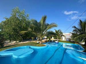 布韦朱HOOM的一座种植了树木和棕榈树的大型蓝色游泳池