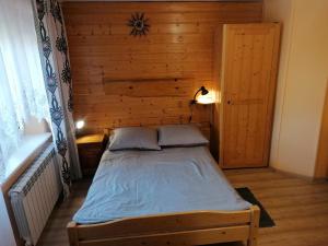Grywałd与伯泽娜和艾德克特卡兹克一起度假农家乐的木墙客房的一张床位