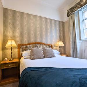 乔利肖赫尔高尔夫酒店及乡村俱乐部的一间卧室配有一张大床和两盏灯。