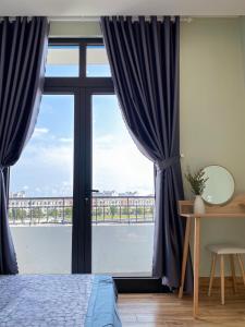 富国Homestay Sài Gòn的一间卧室设有大窗户和蓝色窗帘
