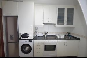 菲尼斯特雷Apartamento Mar de Ardora Finisterre的白色的厨房配有水槽和洗碗机
