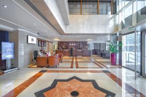 迪拜Majestic Premier Hotel Burdubai的大楼的大堂,配有桌椅