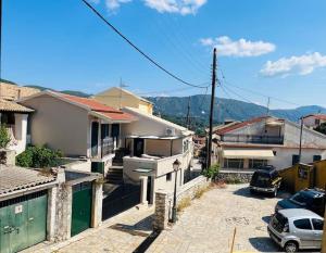 里亚帕德斯Traditional Detached Corfu House, 50m to village square的一群有车停在停车场的房屋