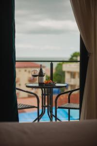 乌雷基Ritsa Resort的阳台上的桌子和两杯葡萄酒