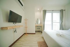 Ban KoNut Home Hostel的一间卧室配有一张床和一台平面电视