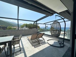 古泽尔坎里Artan Suites Tatil Evleri的阳台配有桌椅,享有海景。