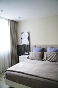 八打灵再也Modern & Minimalist 2-Bedroom Apartment in PJ的一间卧室配有一张带蓝色枕头的大床