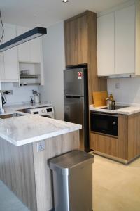 八打灵再也Modern & Minimalist 2-Bedroom Apartment in PJ的厨房配有不锈钢冰箱和白色橱柜