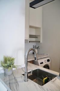 八打灵再也Modern & Minimalist 2-Bedroom Apartment in PJ的厨房水槽和柜台上的水龙头