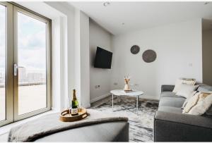 曼彻斯特3 bed luxury spacious apartment with pool的带沙发和大窗户的客厅