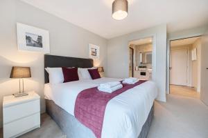 泰晤士河畔金斯顿Roomspace Serviced Apartments- Buttermere House的卧室配有一张白色大床和紫色毯子