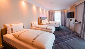 曼海姆Premier Inn Mannheim City Centre的酒店客房,设有两张床和一张沙发