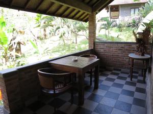 塔巴南Kebun Villa, Belimbing, Bali的门廊上的桌椅,窗户