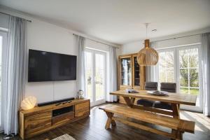 特伦特Haus in idyllischer Lage mit Sauna, Terrasse und Garten - Villa Morgensünn的客厅配有电视和木桌