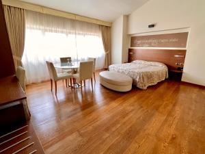 洛韦雷洛唯雷温泉度假酒店的卧室配有一张床和一张桌子及椅子