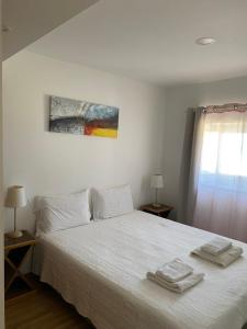 佩尼契Casa Berlengas a Vista的卧室配有白色的床和2条毛巾
