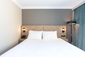 温哥华Sandman Hotel Vancouver Downtown的卧室配有一张带两个枕头的大白色床