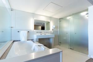 布鲁堡史特兰Blaauwberg Beach Hotel的白色的浴室设有水槽和淋浴。