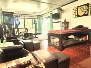 清迈Benji Home的一间带桌子的客厅和一个健身房