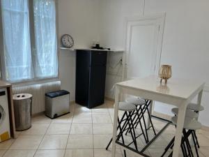 瑟农Maison - jardin aux portes de Bordeaux的一间厨房,里面配有白色的桌子和椅子