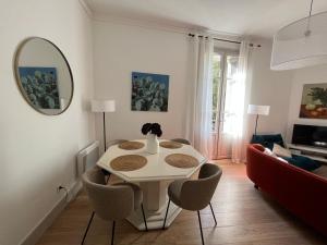 尼姆Nimes , appartement rénové dans immeuble classé.的客厅配有桌椅和镜子