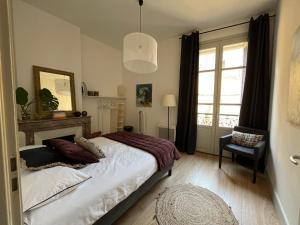 尼姆Nimes , appartement rénové dans immeuble classé.的一间卧室设有一张床和一个大窗户