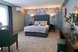 吉尔福德Mandolay Hotel Guildford的一间卧室配有一张带花卉壁纸的床