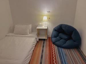 恒春古城Back to spring BnB的一间卧室配有一张床和一张蓝色椅子