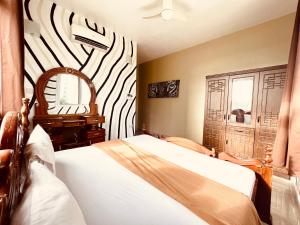 Kiembi SamakiAfrica Mbweni Apartment的一间卧室配有一张床和斑马主题的墙壁
