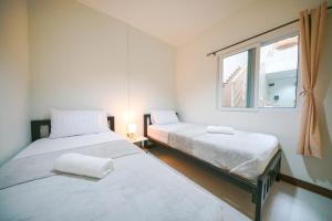 Ban KoNut Home Hostel的带窗户的客房内的两张床