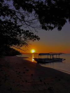 瑟克通巴尔米拉英达简易别墅酒店的日落时分在海滩上乘船