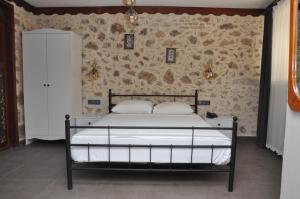 安塔利亚La Casa Carina Butik Otel的卧室内的一张床位,卧室设有石墙