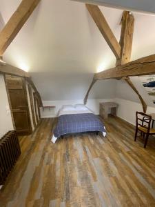马耶讷Appartement au manoir de la grande vigne Mayenne的铺有木地板的客房内设有一间卧室和一张床。