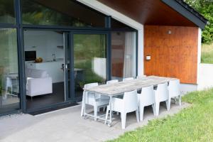 温特贝格Villas Winterberg的庭院里设有一张木桌和白色椅子