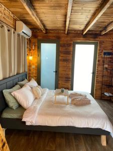 Dāliyat el KarmilT&S suite的一间带一张大床的卧室,位于带木墙的房间