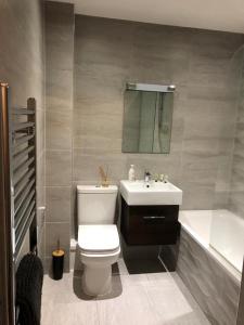 基督城Charming 2-Bed Apartment in Christchurch的浴室配有卫生间、盥洗盆和浴缸。