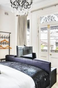 悉尼Refined Paddington Corner Terrace with Parking的一间卧室配有一张大床和一个吊灯。