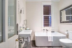 悉尼Refined Paddington Corner Terrace with Parking的白色的浴室设有浴缸和水槽。