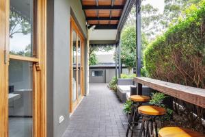 悉尼Refined Paddington Corner Terrace with Parking的门廊,房子有凳子和长凳