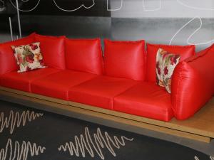 萨尔瓦多萨尔瓦多红河宜必思酒店的客房内的红色沙发,配有枕头