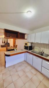 蓝海湾Oasis Appartement的厨房配有白色橱柜和台面