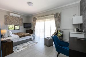 比勒陀利亚The African Penguin Guesthouse的一间卧室配有一张床、一张书桌和一个窗户。
