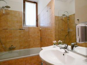 圣佩莱格里诺温泉Baciati dal Sole-Self check-in的浴室配有水槽、淋浴和浴缸。