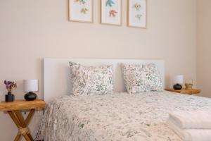 埃斯波森迪Litoral beach Apartment -- Esposende的一间卧室配有一张带两盏灯和两个枕头的床。