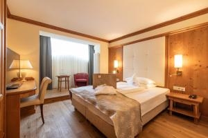 奥蒂塞伊拉佩拉阿尔平与维塔尔酒店的配有一张床和一张书桌的酒店客房