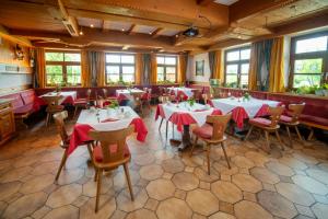 彭茨贝格Landhotel Hoisl-Bräu的餐厅配有桌椅和红色餐巾