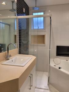 瓜鲁雅CARIBONI的一间带水槽和玻璃淋浴间的浴室